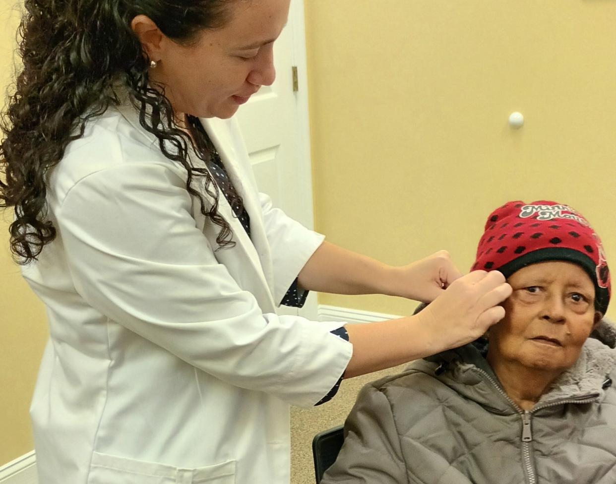 Dr. Kristen Weinbaum, owner of Precision Hearing in Clermont, fits hearing aids on Martha Moone, a winner of her annual giveaway.