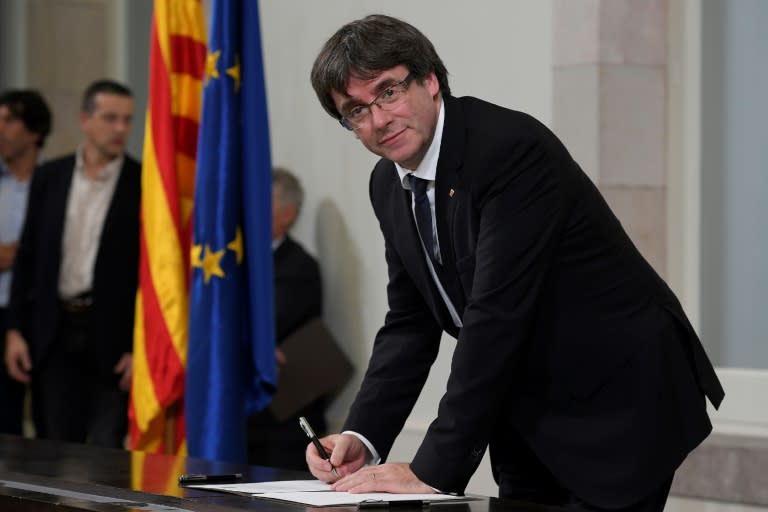 Catalan regional government president Carles Puigdemont signs a document about the independence of Catalonia at the Catalan regional parliament in Barcelona on October 10, 2017