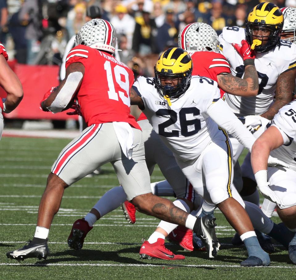 Michigan defensive lineman Rayshaun Benny (26) tackles Ohio State running back Chip Trayanum during the first half at Ohio Stadium in Columbus on Nov. 26, 2022.