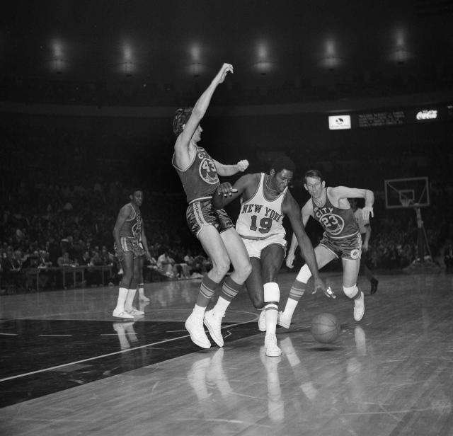 FILE - New York Knicks Willis Reed (19) drives against San Francisco Warrior Clyde Lee (43) during an NBA game at Madison Square Garden in New York, March 4, 1970. At right is San Francisco Warrior Jeff Mullins (23). Willis Reed, who dramatically emerged from the locker room minutes before Game 7 of the 1970 NBA Finals to spark the New York Knicks to their first championship and create one of sports’ most enduring examples of playing through pain, died Tuesday, March 21, 2023. He was 80. Reed's death was announced by the National Basketball Retired Players Association, which confirmed it through his family. (AP Photo/John Lent, File)