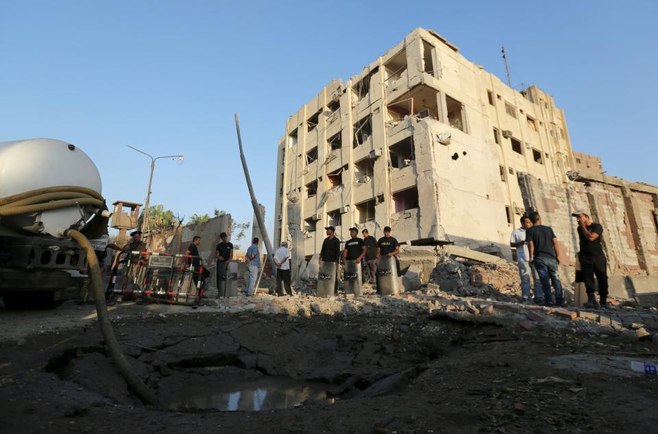 Security officials stand guard at the site of a bomb blast at a state security building in Shubra Al-Khaima, on the outskirts of Cairo