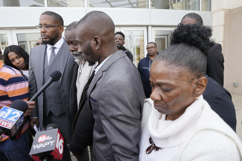 Melvin Jenkins, second from left, speaks to reporters while standing with lead civil attorney Malik Shabazz, left, and his son Michael Corey Jenkins, second from right, and wife Mary Jenkins, regarding the sentencing of the third of six former Rankin County law enforcement officers, who committed numerous acts of racially motivated, violent torture on his son Michael and his friend Eddie Terrell Parker in 2023., while outside the federal courthouse in Jackson, Miss., Wednesday, March 20, 2024. Former Rankin County deputy Daniel Opdyke was sentenced to 17.5 years in federal prison for his actions. (AP Photo/Rogelio V. Solis)