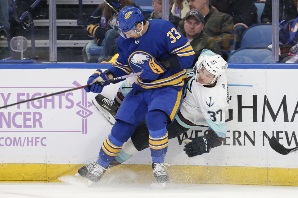 Seattle Kraken center Yanni Gourde (37) is checked by Buffalo Sabres defenseman Colin Miller (33) during the second period of an NHL hockey game, Monday, Nov. 29, 2021, in Buffalo, N.Y. (AP Photo/Jeffrey T. Barnes)