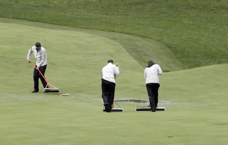 Groundskeepers work to squeegee excess water off a fairway during rain delay at the start of the second round of the PGA Championship at Valhalla Golf Club in Louisville, Kentucky, August 8, 2014. REUTERS/John Sommers II