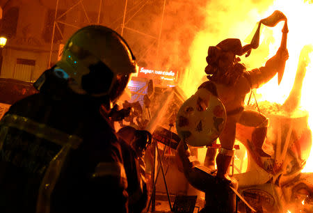 Firemen spray water on figures of a monument as it burns during the finale of the Fallas festival, which welcomes Spring and commemorates Saint Joseph's Day, in Valencia early March 20, 2019. REUTERS/Heino Kalis