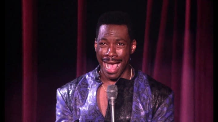 Eddie Murphy mouth wide open saying something to a mic in Eddie Murphy Raw.