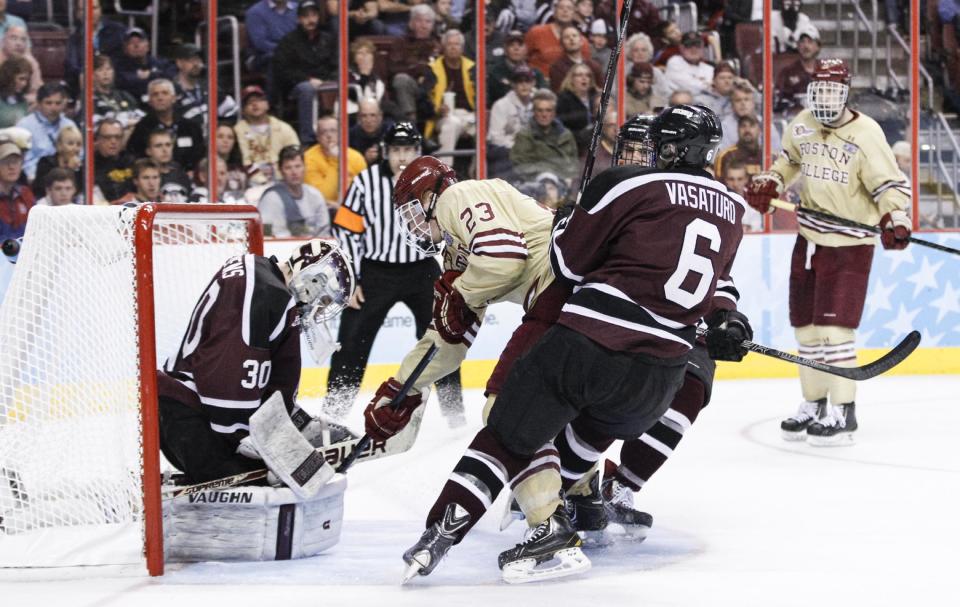 Union's Colin Stevens, left, stops a hot by Boston College's Patrick Brown, center, with Union's Charlie Vasaturo, right, and Cole Ikkala looking on during the third period of an NCAA men's college hockey Frozen Four tournament game on Thursday, April 10, 2014, in Philadelphia. Union College won 5-4. (AP Photo/Chris Szagola)