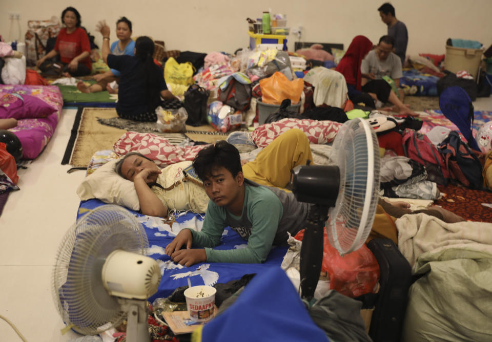 People rest at a temporary shelter for those affected by the floods in Jakarta, Indonesia, Friday, Jan. 3, 2020. Severe flooding in the capital as residents celebrated the new year has killed dozens of people and displaced hundreds of thousands others. (AP Photo/Dita Alangkara)