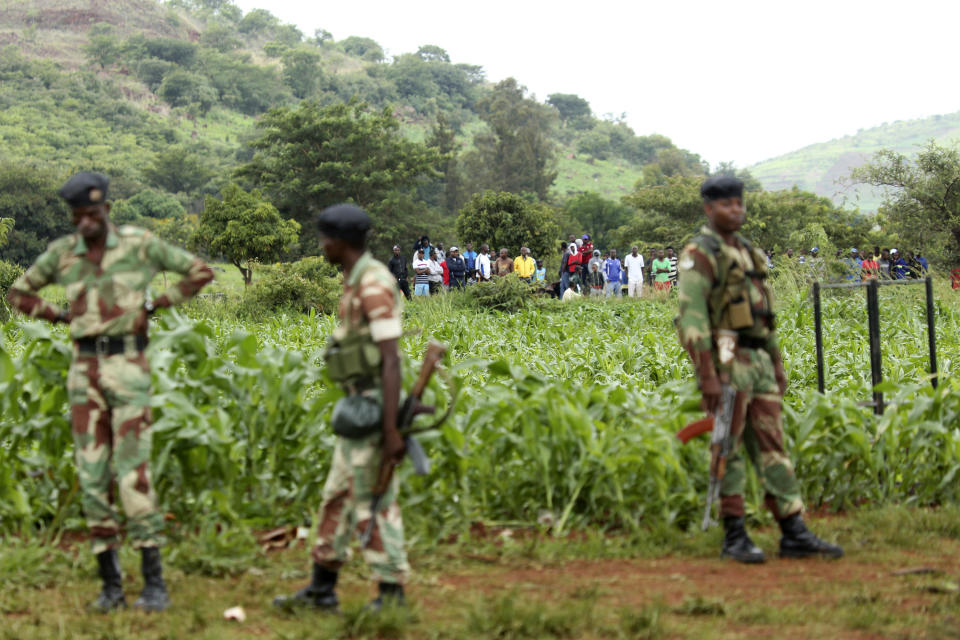 Soldiers patrol as protestors gather during a demonstration over the hike in fuel prices in Harare, Zimbabwe, Tuesday, Jan. 15, 2019. A Zimbabwean military helicopter on Tuesday fired tear gas at demonstrators blocking a road and burning tires in the capital on a second day of deadly protests after the government more than doubled the price of fuel in the economically shattered country. (AP Photo/Tsvangirayi Mukwazhi)