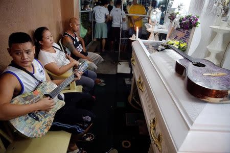 Friends and relatives of Florjohn Cruz, who was killed in a police drugs buy-bust operation, gather around his coffin during his wake in Manila, Philippines late October 20, 2016. REUTERS/Damir Sagolj/Files