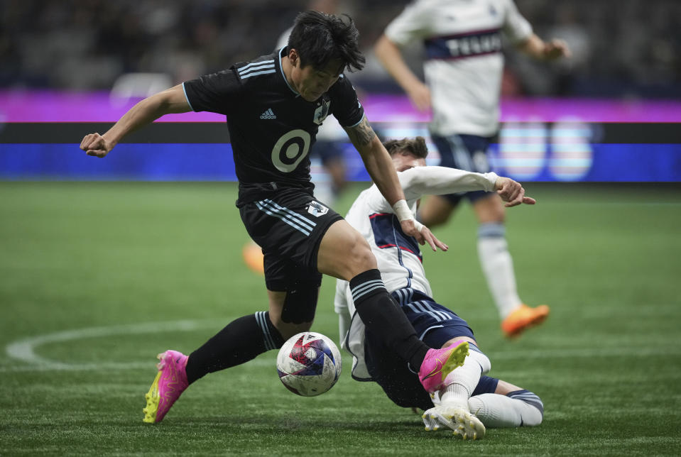 Minnesota United's Jeong Sang-bin, front left, and Vancouver Whitecaps' Tristan Blackmon vie for the ball during the first half of an MLS soccer match in Vancouver, British Columbia, Saturday, May 6, 2023. (Darryl Dyck/The Canadian Press via AP)