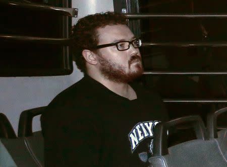 Rurik George Caton Jutting, a British banker charged with two counts of murder after police found the bodies of two women in his apartment, sits in the back row of a prison bus as he arrives at the Eastern Law Courts in Hong Kong November 24, 2014. REUTERS/Bobby Yip