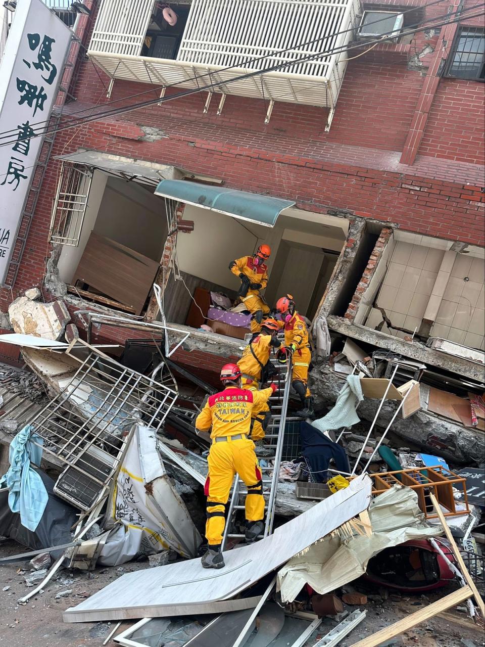 A search and rescue team prepare to enter a leaning building in the aftermath of the earthquake (AP)