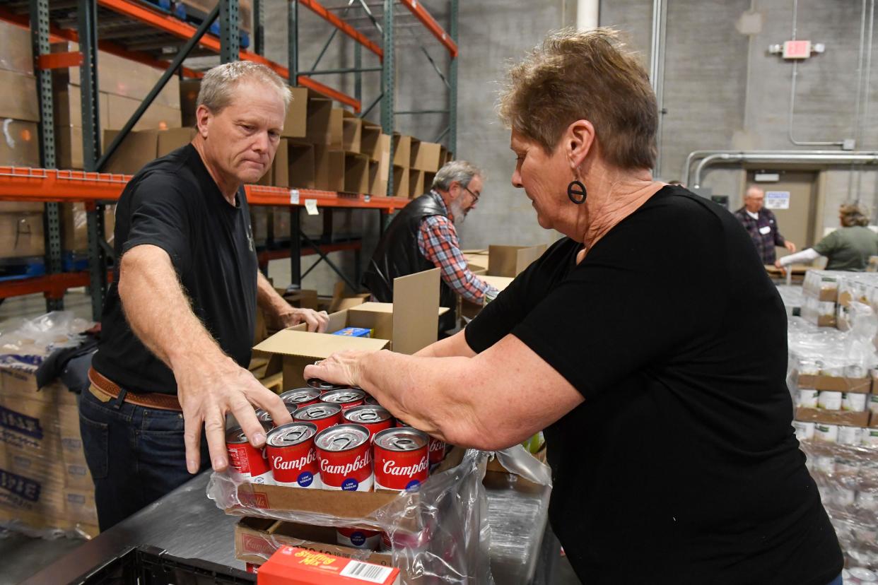 Volunteers Lori Schmidt and Jay Bobb pack boxes of food with Feeding South Dakota on Thursday, December 8, 2022, in Sioux Falls.