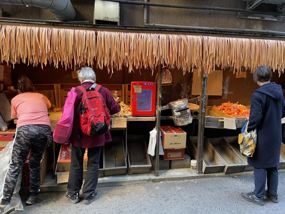 Japanese farmer Tomoko Oshimo, or Tomo-chan, is seen (at left) stocking her fresh produce stall in Tokyo's trendy Ebisu district. / Credit: CBS News