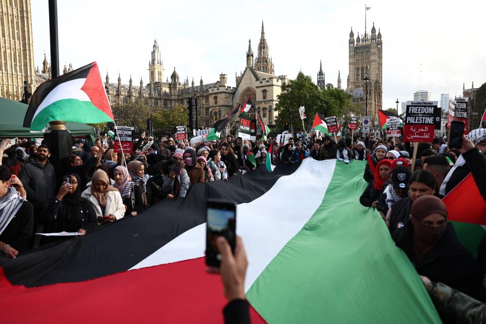 Protesters display a large Palestinian flag in Parliament Square after taking part in a 'March For Palestine' in London on October 28, 2023, to call for a ceasefire in the conflict between Israel and Hamas. Thousands of civilians, both Palestinians and Israelis, have died since October 7, 2023, after Palestinian Hamas militants based in the Gaza Strip entered southern Israel in an unprecedented attack triggering a war declared by Israel on Hamas with retaliatory bombings on Gaza. (Photo by HENRY NICHOLLS / AFP) (Photo by HENRY NICHOLLS/AFP via Getty Images)