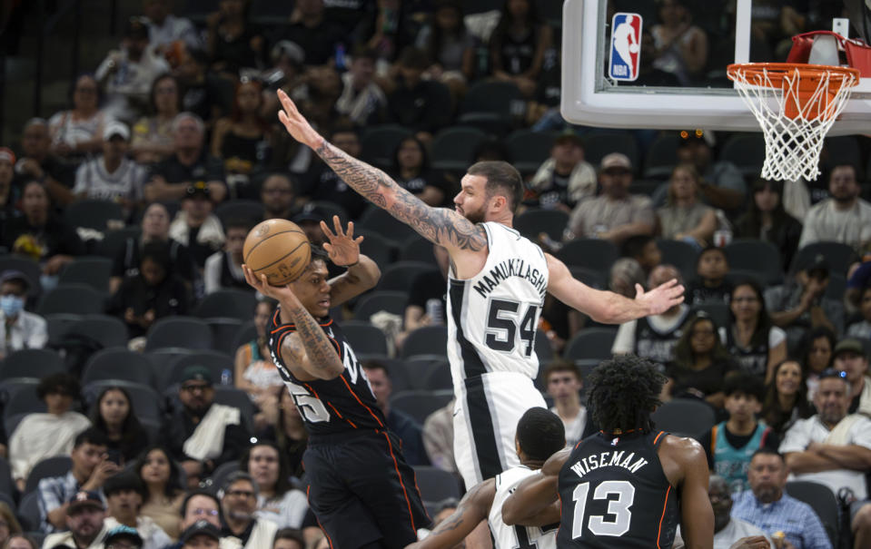 Detroit Piston guard Marcus Sasser, left, looks to pass against San Antonio Spurs forward Sandro Mamukelashvili (54) during the first half of an NBA basketball game, Sunday, April 14, 2024, in San Antonio, Texas. (AP Photo/Michael Thomas)