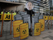 A member of youth groups wearing a cutout of Japanese Prime Minister Yoshihide Suga performs to denounce his government's decision, in Seoul, South Korea, Tuesday, April 13, 2021. Japan's government decided Tuesday to start releasing massive amounts of treated radioactive water from the wrecked Fukushima nuclear plant into the Pacific Ocean in two years - an option fiercely opposed by local fishermen and residents. (AP Photo/Lee Jin-man)