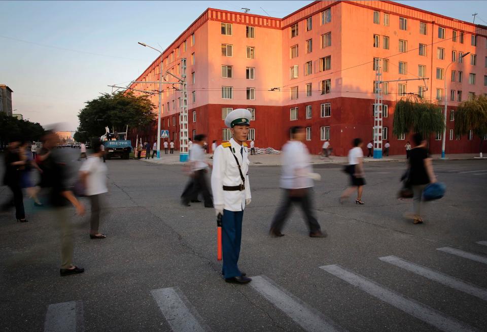 A traffic policeman directs pedestrians leaving an anti-U.S. rally that marked the 66th anniversary of the start of the Korean War at Kim Il Square in Pyongyang, North Korea, on June 25, 2016.