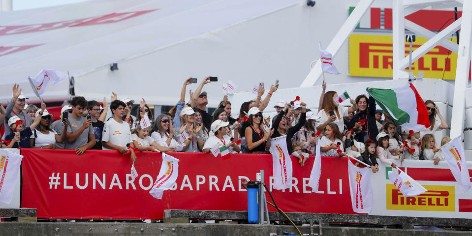 Supporters of Italy's Luna Rossa wave as it returns to base following its win over American Magic in the America's Cup challenger series semifinals on Auckland's Waitemate Harbour, New Zealand, Saturday, Jan. 30, 2021. (Dean Purcell/NZ Herald via AP)