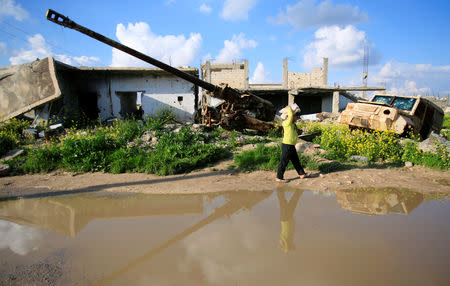 A boy walks as he holds stacks of bread on his head in Kobani, Syria April 3, 2019. REUTERS/Ali Hashisho