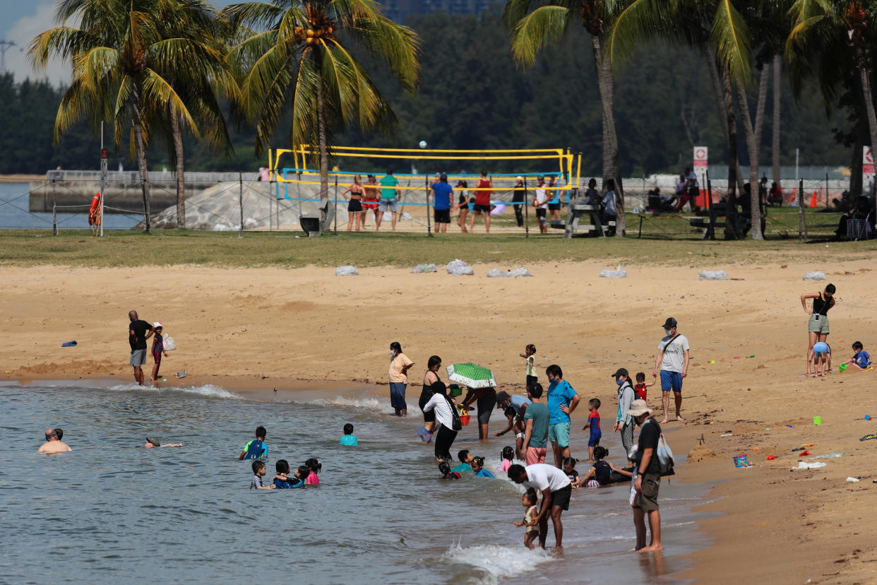 People swim and play volleyball at the beach on August 15, 2021 in Singapore. (Photo by Suhaimi Abdullah/NurPhoto via Getty Images)