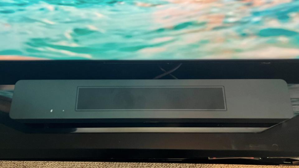 Bose Soundbar 600 on TV stand with blue screen in background