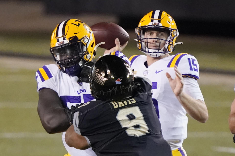 LSU quarterback Myles Brennan (15) passes as he is pressured by Vanderbilt defensive lineman Alex Williams (8) in the first half of an NCAA college football game Saturday, Oct. 3, 2020, in Nashville, Tenn. (AP Photo/Mark Humphrey)