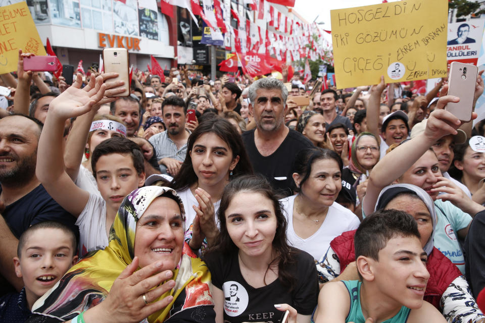 In this Wednesday, June 19, 2019 photo, supporters of Ekrem Imamoglu, candidate of the secular opposition Republican People's Party, or CHP watch him delivering a speech during a rally in Istanbul, ahead of the June 23 re-run of Istanbul elections. The 49-year-old candidate won the March 31 local elections with a slim majority, but after weeks of recounting requested by the ruling party, Turkey's electoral authority annulled the result and ordered the new election. (AP Photo/Lefteris Pitarakis)