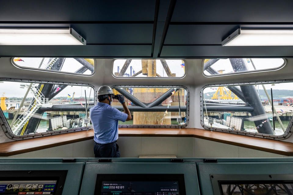 An employee uses binoculars inside a control room of the Multi-purpose Mobile Base flat bottom ship developed by the Korea Electric Power Corp. during an unveiling ceremony in Gunsan, South Korea, on July 7, 2021. (SeongJoon Cho / Bloomberg via Getty Images file)