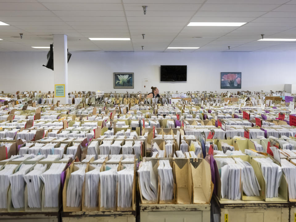 Margaret Moore, an IRS clerk, searches through taxpayer documents that have been stored in the IRS cafeteria due to a lack of space at the Internal Revenue Service in Austin, Tx., on Friday, June 10, 2022. (Credit: Matthew Busch for The Washington Post via Getty Images)