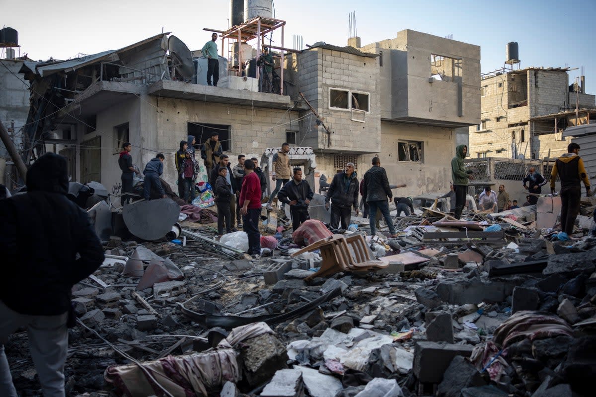 Palestinians look at houses destroyed in the Israeli bombardment of the Gaza Strip in Rafah (AP)