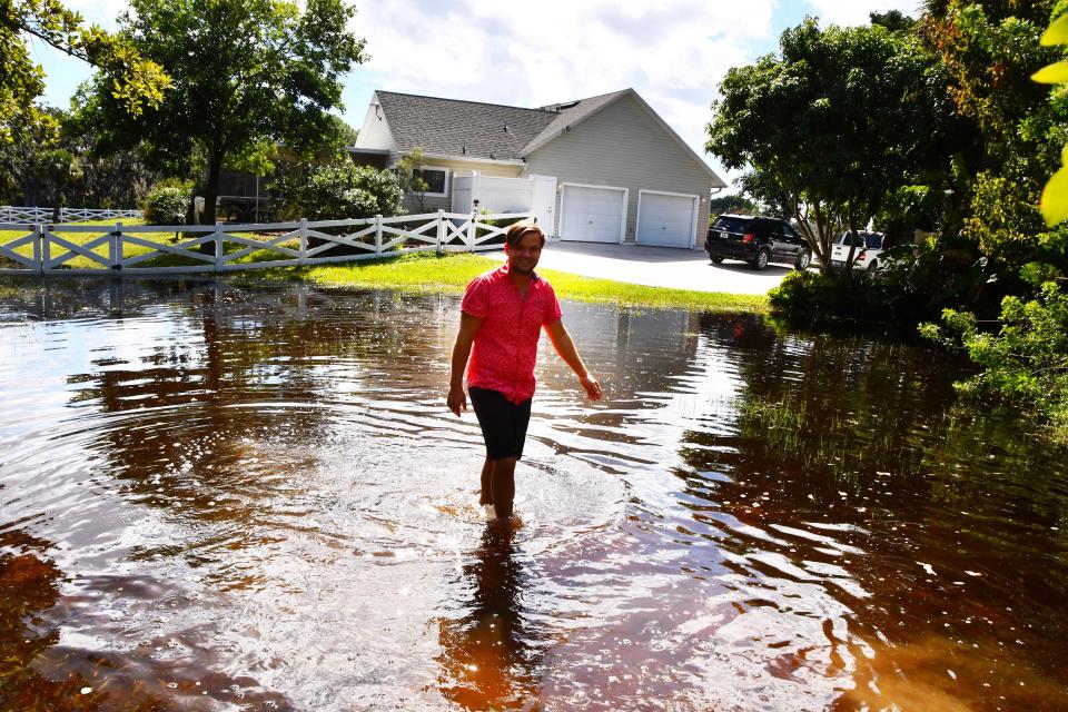 While life is back to normal for most people from Hurricane Ian in Brevard, some places in north Merritt Island are still flooded. Keith Alderman walks down his driveway on Judson Road. Their house is dry, but Keith and his family have been trapped in their home since Wednesday from flood waters.