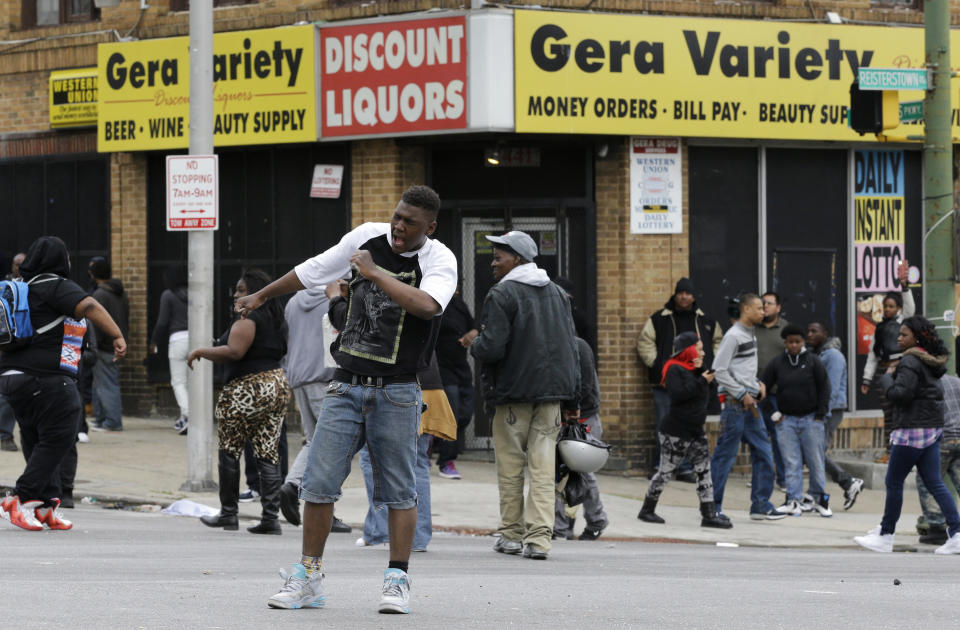 A man dances in an intersection, Monday, April 27, 2015, during unrest following the funeral of Freddie Gray in Baltimore. Gray died from spinal injuries about a week after he was arrested and transported in a Baltimore Police Department van. (AP Photo/Patrick Semansky)
