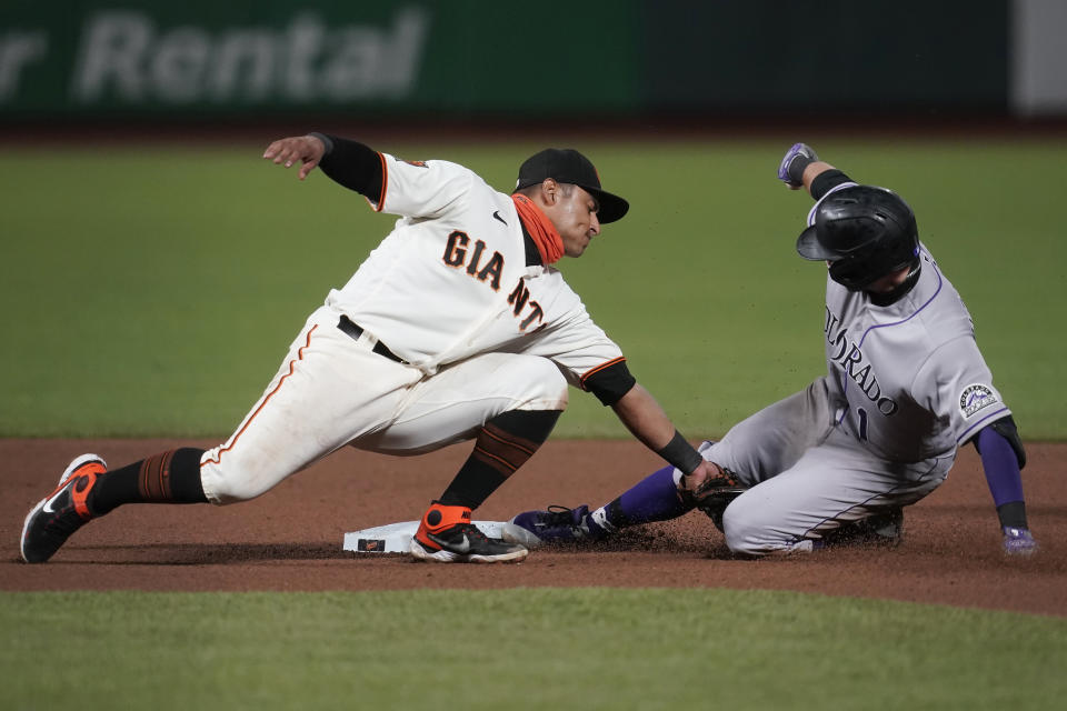 Colorado Rockies' Garrett Hampson, right, is tagged out by San Francisco Giants second baseman Donovan Solano trying to stretch his single during the seventh inning of a baseball game in San Francisco, Tuesday, Sept. 22, 2020. (AP Photo/Jeff Chiu)