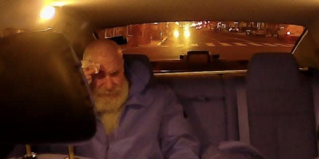 Jerry Daniel Braun holds his head in the back of an Uber.