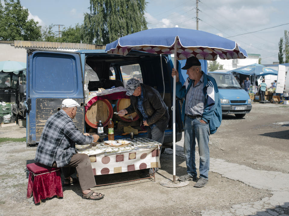 Gheorghe sells homemade wine at the Sunday markey in Straseni, Moldova, on Aug. 2, 2019. | Ramin Mazur for TIME