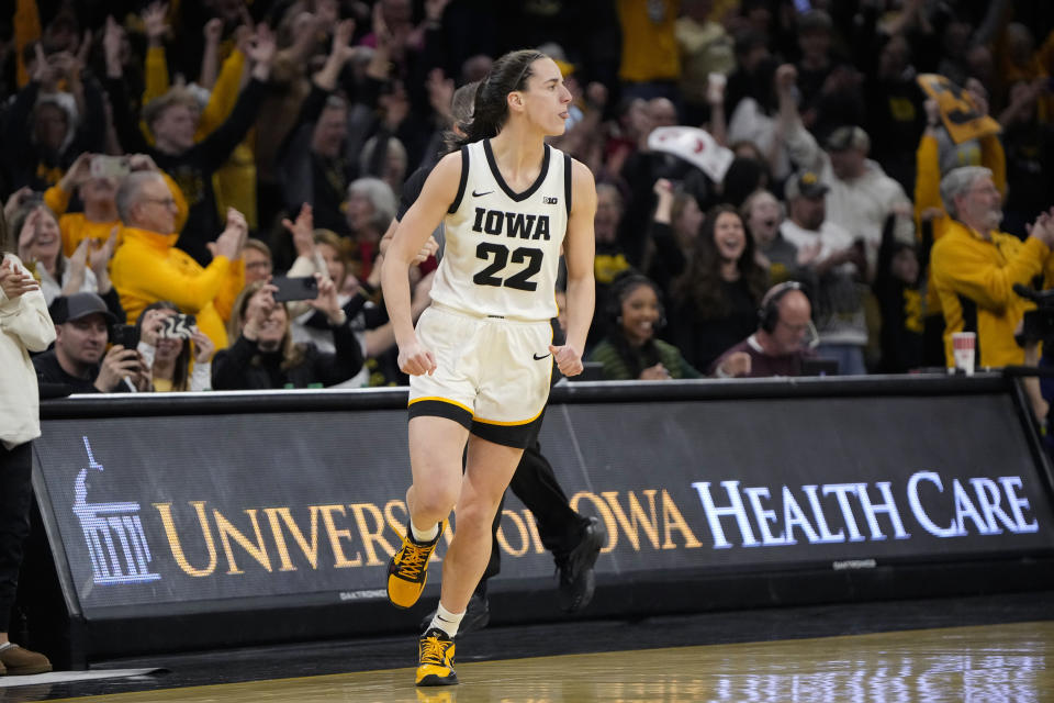 Iowa guard Caitlin Clark (22) reacts after breaking the NCAA women's career scoring record during the first half of the team's college basketball game against Michigan, Thursday, Feb. 15, 2024, in Iowa City, Iowa. (AP Photo/Matthew Putney)