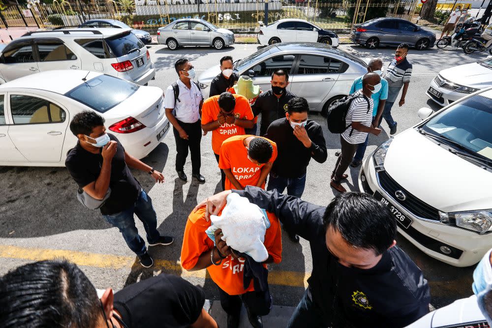 MACC personnel escort four detainees to be remanded at the George Town Magistrate’s Court February 26, 2021. — Picture by Sayuti Zainudin