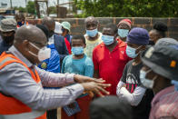 Residents listen to Gauteng Province Premier David Makhura in Lawley, South Africa, Friday Dec. 3, 2021 for the launch of the Vooma vaccination program against COVID-19. South Africa has accelerated its vaccination campaign a week after the discovery of the omicron variant of the coronavirus. (AP Photo/Jerome Delay)