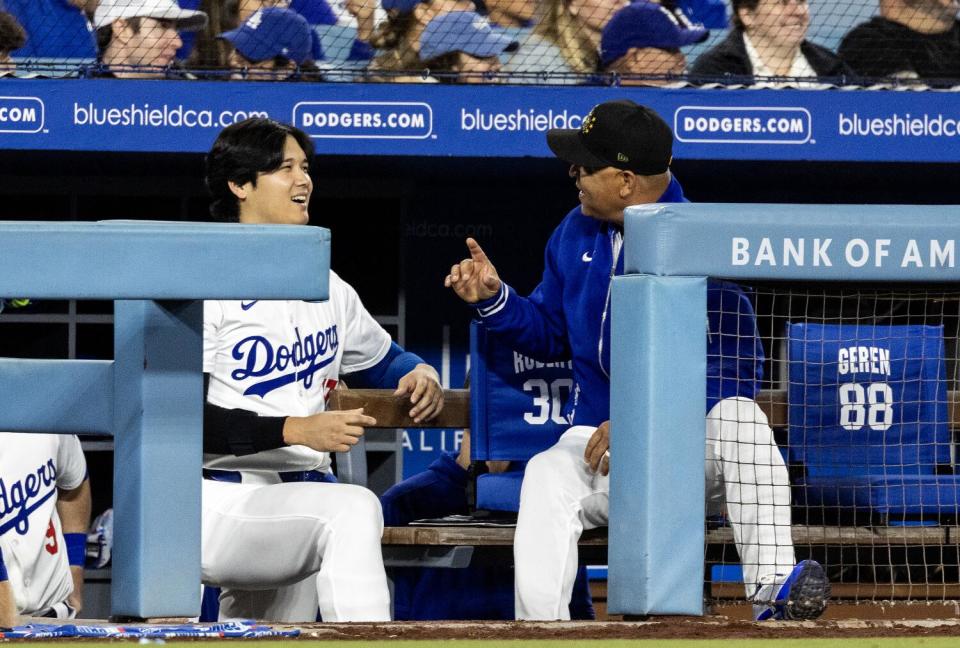 Dodgers aangewezen slagman Shohei Ohtani, links, praat met manager Dave Roberts op de dug-outtrap.