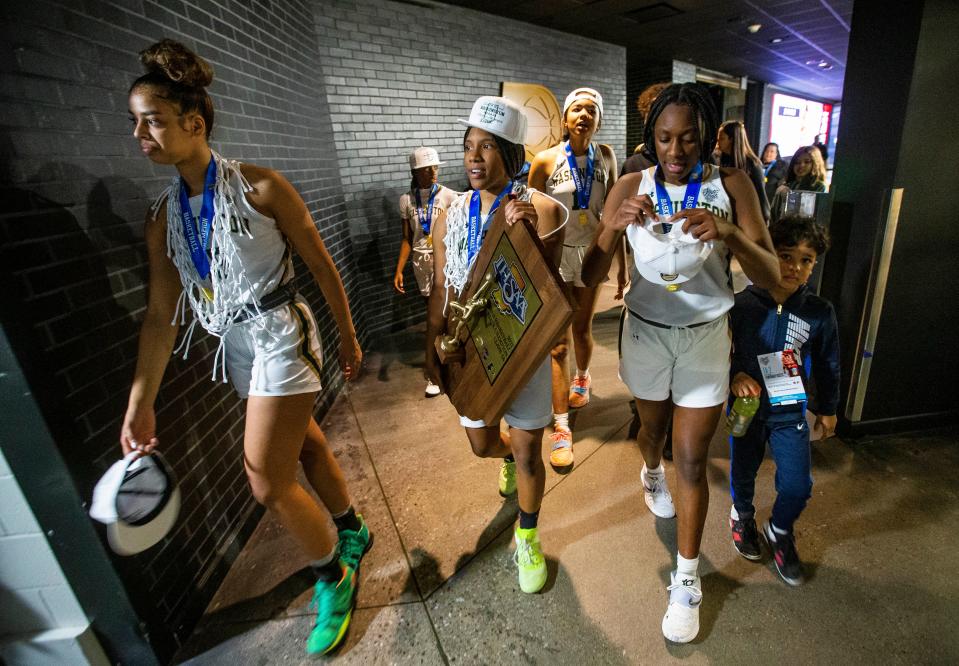 Washington's Mila Reynolds (15) Shamarah Allen (14) and Monique Mitchell (35) walk to the locker room with the trophy after winning the Washington vs. Silver Creek girls state championship basketball game Saturday, Feb. 26, 2022 at Gainbridge Fieldhouse in Indianapolis. 
