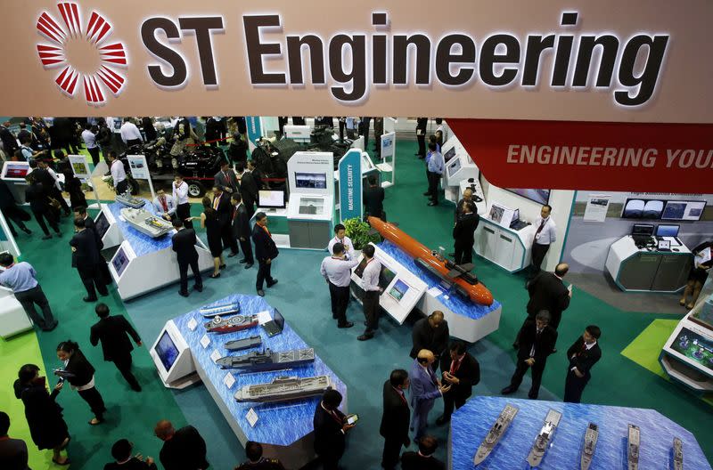 FILE PHOTO: FILE PHOTO: Visitors look at displays at the Singapore Technology (ST) Engineering booth during the opening day of the Singapore Airshow at Changi Exhibition Center