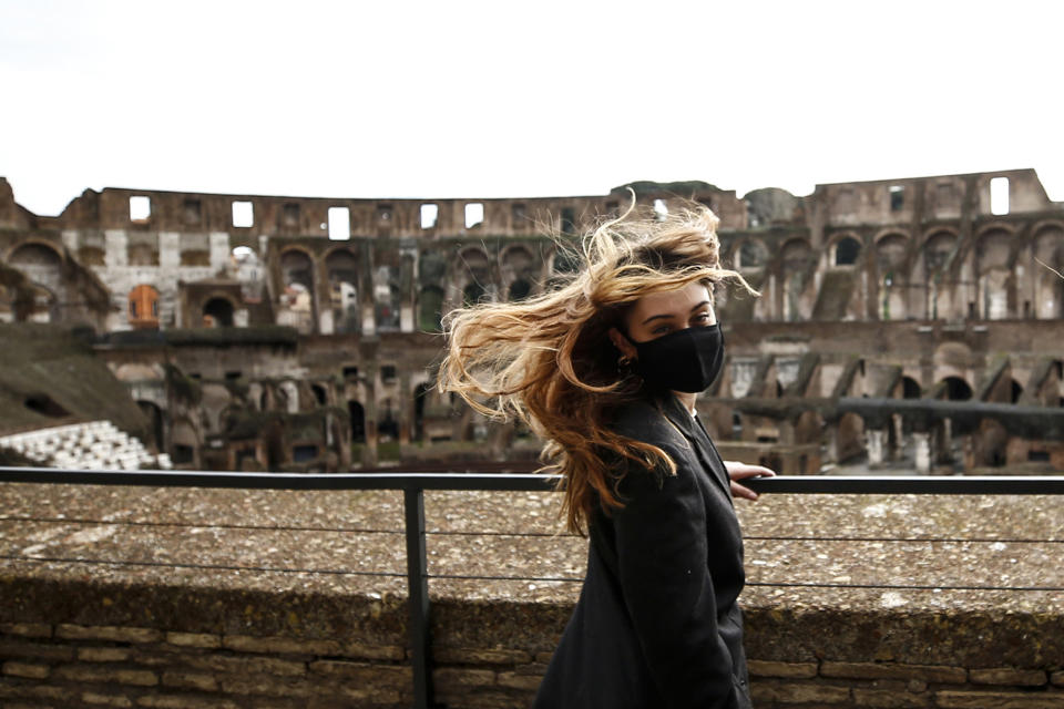 A woman visits the Rome's ancient Colosseum after its reopening Monday, Feb. 1, 2021, in a partial lifting of restriction measures aimed at containing the spread of COVID-19. Italy has eased its coronavirus restrictions Monday for most of the country downgrading Lazio and other regions from medium-risk orange zones to lower-risk yellow zones. (Cecilia Fabiano /LaPresse via AP)