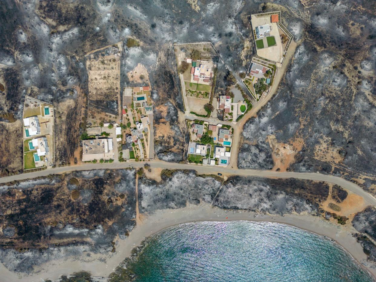 An aerial view of houses among burned land, as a wildfire burns on the island of Rhodes (REUTERS)