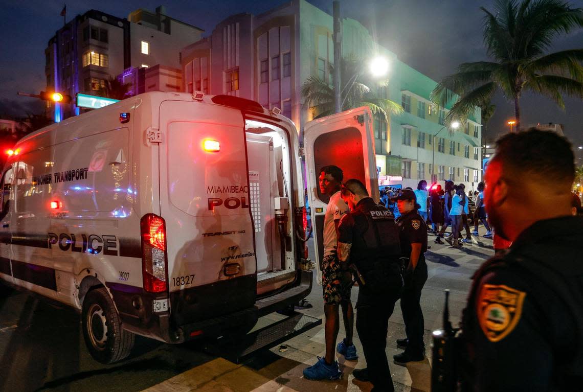 Miami Beach police officers load a detainee into a police transport vehicle on Ocean Drive across during spring break on Miami Beach, Florida on Saturday, March 16, 2024.