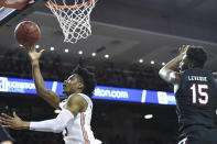 Auburn forward Isaac Okoro (23) scores two over South Carolina forward/center Wildens Leveque (15) during the second half of an NCAA college basketball game Wednesday, Jan. 22, 2020, in Auburn, Ala. (AP Photo/Julie Bennett)