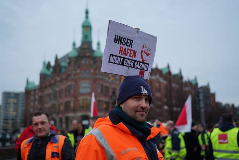 People take part in a demonstration in the Speicherstadt against the sale of shares in Hamburger Hafen und Logistik AG (HHLA) to the Italian shipping company MSC. Marcus Brandt/dpa