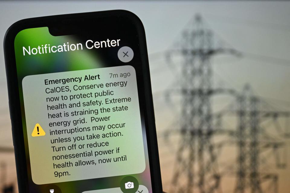 An Apple iPhone shows an Emergency Alert notification from CalOES urging the public to conserve energy to protect health and safety as the electricity grid is strained during a heat wave in Los Angeles, California on September 6, 2022.