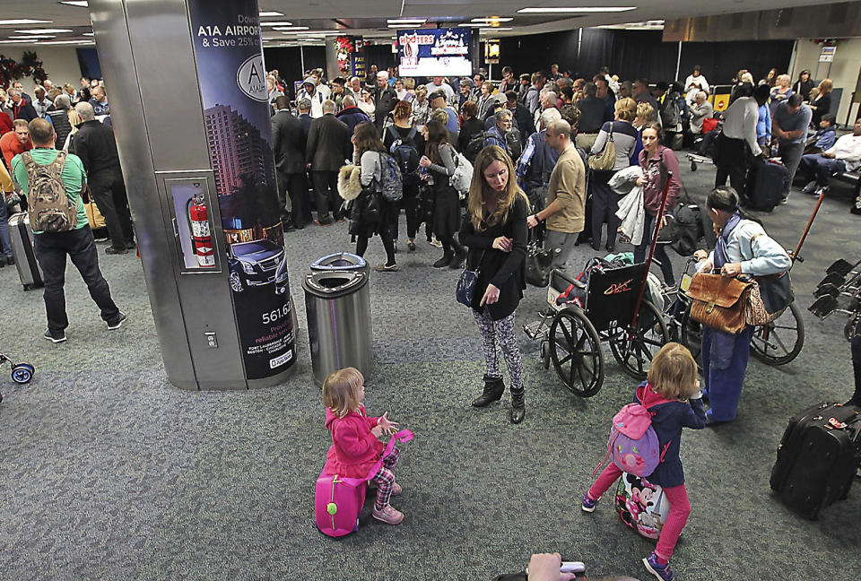 A crowd gathers around the baggage carousel in terminal 2 at Fort Lauderdale-Hollywood International Airport in Fort Lauderdale, Fla., Sunday, Jan. 8, 2017. (Patrick Farrell/Miami Herald via AP)